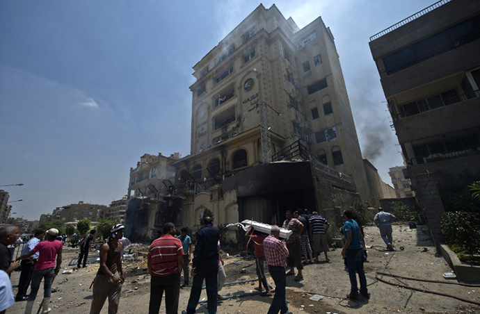 Egyptians gather outside the burnt
headquarters of the Muslim Brotherhood in the Moqattam district
of Cairo on July 1, 2013 after it was set ablaze by opposition
demonstrators overnight. (AFP Photo / Khaled Desouki)