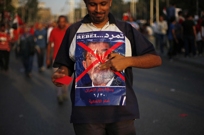 A protester opposing
Egyptian President Mohamed Morsi holds an anti-Morsi poster
during a protest in front of the presidential palace in Cairo
June 30, 2013. (Reuters)